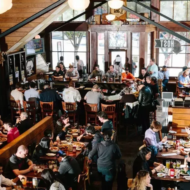 Los clientes comen y beben dentro de la cervecería 21st Enmienda 在贝博体彩app.